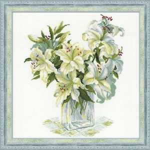 May include: A cross-stitch floral design featuring a bouquet of white lilies with yellow centers and green leaves in a clear glass vase. The artwork is framed in a light blue decorative border, creating a classic and elegant aesthetic.