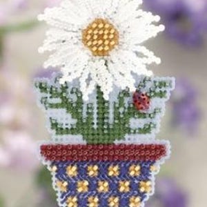 May include: A beaded daisy flower in a blue and red flower pot. The flower has white petals and a yellow center. The pot is decorated with yellow flower shapes. A small red ladybug sits on the pot.