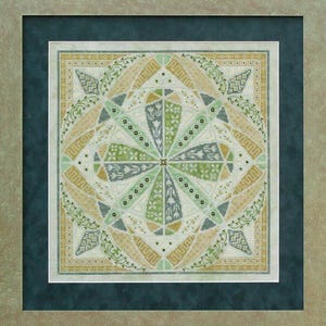 Puede incluir: Obra de arte de punto de cruz enmarcada con un diseño geométrico simétrico. La pieza presenta un patrón central de estrella en tonos verdes, azules y beige, rodeado de intrincados bordes florales y geométricos. La obra está enmarcada en un passe-partout verde azulado oscuro y un marco de tonos neutros.
