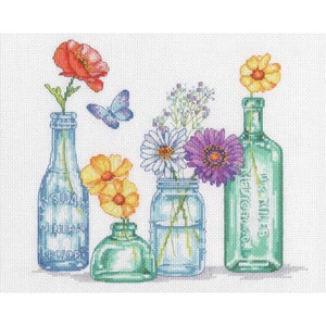 May include: Cross-stitch design featuring colorful flowers in vintage glass bottles and jars. A red poppy, yellow daisies, purple gerbera, and white flowers are arranged in blue, green, and clear glass containers. A butterfly hovers above the arrangement.