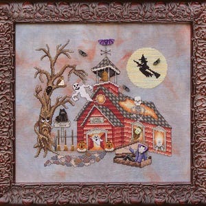 Puede incluir: Obra de arte de punto de cruz de una escena escolar espeluznante con una bruja volando junto a una luna llena. La escuela tiene un tejado rojo y el texto "Ghouls School". Un árbol, fantasmas y calabazas completan el tema de Halloween. La obra está enmarcada en un marco marrón ornamentado.