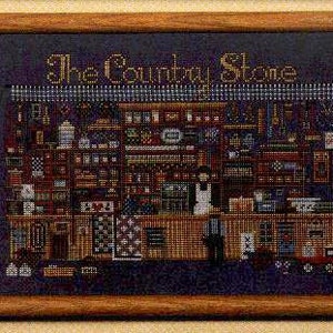 Könnte beinhalten: Gerahmtes Kreuzstich-Kunstwerk, das eine detaillierte Innenszene eines Ladens darstellt. Der Text "The Country Store" ist in Goldfaden gestickt. Das Ladeninnere ist mit Regalen und verschiedenen Gegenständen gefüllt, alles in Kreuzstich dargestellt.