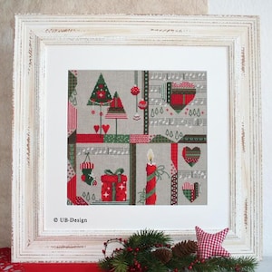May include: Framed Christmas-themed cross-stitch art. The artwork features red and green Christmas trees, hearts, musical notes, a candle, a gift, and a stocking. The piece is framed in a distressed white wooden frame. The text "UB-Design" is visible.