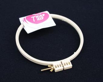 May include: A 7-inch embroidery hoop with a white plastic frame and a gold metal screw. The hoop is labeled "7 NO-SLIP HOOP".