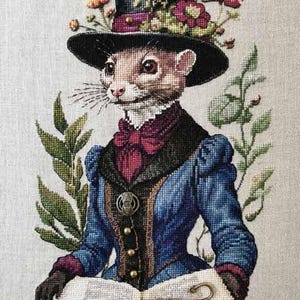 May include: Cross-stitch artwork of a ferret wearing a top hat adorned with flowers. The ferret is dressed in a blue jacket with a burgundy bow tie, holding an open book with a feather bookmark. Green foliage frames the image.