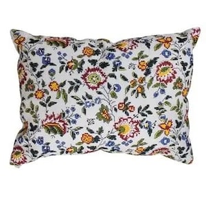 May include: A rectangular decorative pillow with a white background and a floral pattern. The pattern features flowers in shades of red, yellow, blue, and green. The pillow is designed for home decor.