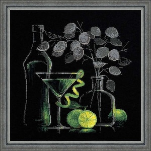 May include: Cross-stitch artwork featuring a green martini, a bottle, and a vase with leafy sprigs. Limes and a lemon twist garnish the cocktail. The artwork is set against a black background and framed in a silver-colored frame.