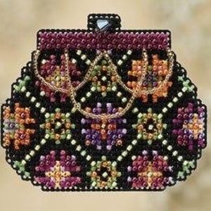 Puede incluir: Un bolso negro con cuentas con un diseño floral decorativo en tonos naranja, morado y verde. El bolso tiene una parte superior burdeos oscuro y un asa de cadena dorada. El cierre es un pequeño cuadrado negro.