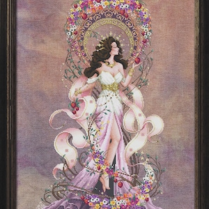May include: Cross-stitch design of a woman in a flowing white and pink gown, holding an apple. She is surrounded by a floral wreath and ribbons, with a dark wooden frame. The design includes the text "BELLA FILIPINA".