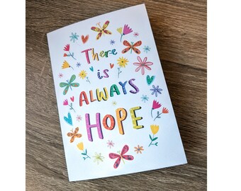 May include: A white card with a colorful floral border and the text "There is ALWAYS HOPE" in rainbow colors.