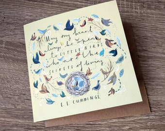 May include: A yellow card with a quote by E.E. Cummings about keeping an open heart. The quote is surrounded by a whimsical illustration of birds, a nest, and feathers.