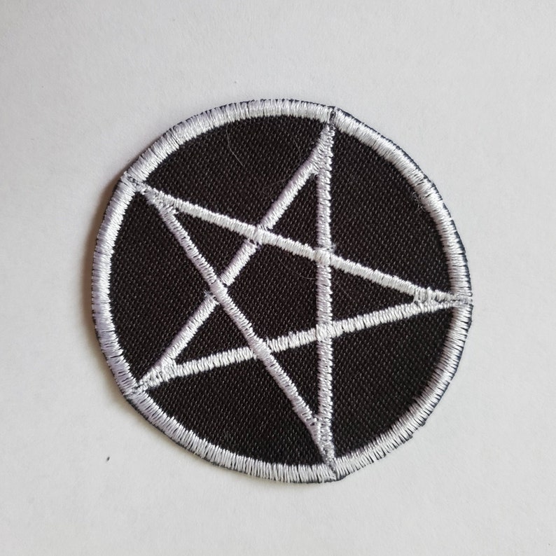 Puede incluir: Parche redondo negro con un dise&ntilde;o de pentagrama bordado en blanco. El pentagrama est&aacute; centrado dentro del c&iacute;rculo, y el borde del parche tambi&eacute;n est&aacute; delineado en blanco. Para ropa o accesorios.