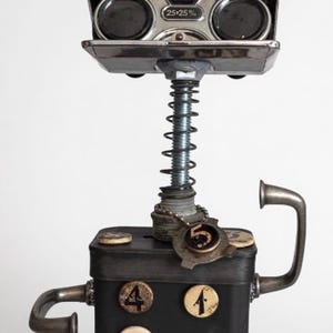 Könnte beinhalten: Eine Mixed-Media-Skulptur mit einem Betrachter im Vintage-Stil auf einer Feder, verbunden mit einer schwarzen Box mit kreisförmigen Akzenten. Die Skulptur hat eine Steampunk-Ästhetik mit metallischen und gealterten Elementen. Der Betrachter hat den Text "25•25 %."