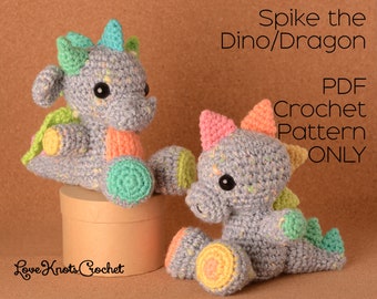 May include: A crochet pattern for a grey and colourful dinosaur or dragon called Spike. The PDF pattern is available to download. The image shows two finished crochet toys.