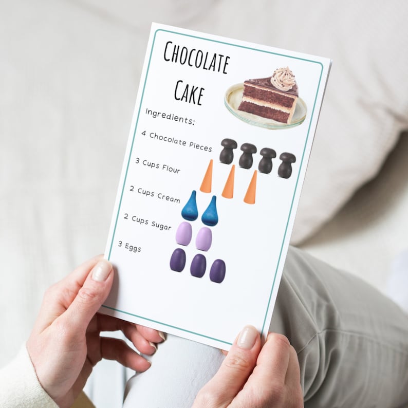 May include: A printable recipe card for chocolate cake with a picture of a slice of chocolate cake and colorful wooden counters to represent the ingredients. The ingredients listed are 4 chocolate pieces, 3 cups flour, 2 cups cream, 2 cups sugar, and 3 eggs.