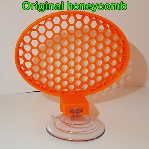 May include: Orange honeycomb-shaped suction cup holder with a clear suction cup base.