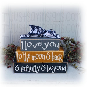 May include: Three wooden blocks stacked on top of each other. The top block is gray and says "I love you". The middle block is yellow and says "to the moon & back". The bottom block is dark blue and says "& infinity & beyond".