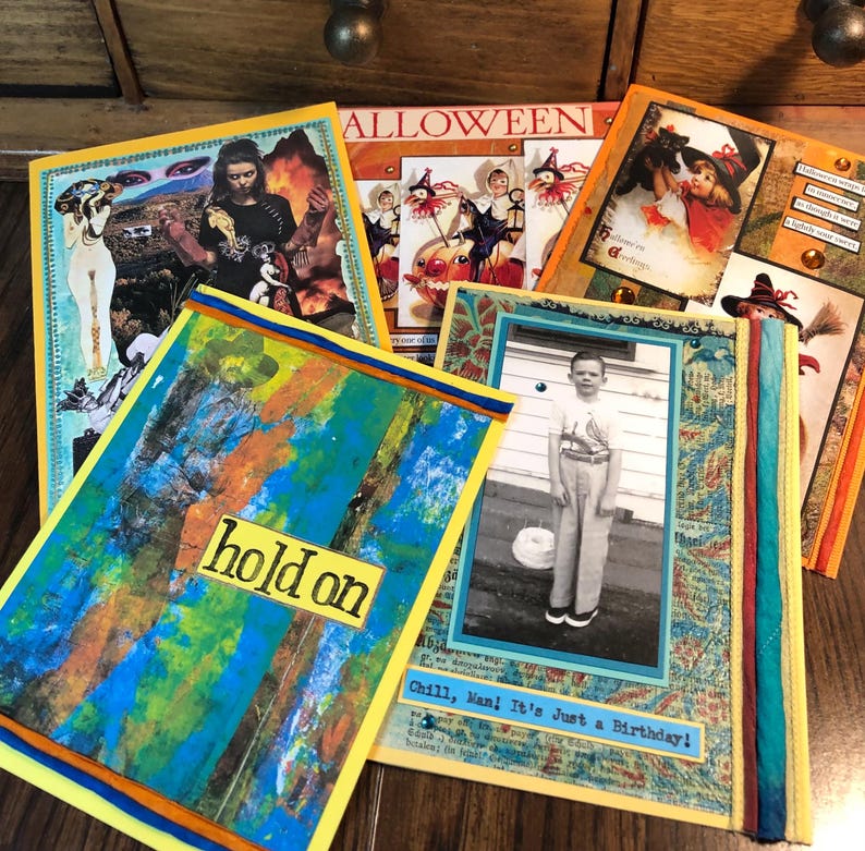 Puede incluir: Una colecci&oacute;n de tarjetas de arte hechas a mano con varios dise&ntilde;os. Una tarjeta presenta el texto "hold on" sobre un fondo abstracto colorido. Otras tarjetas tienen im&aacute;genes y texto vintage, incluyendo un tema de Halloween y una foto en blanco y negro.