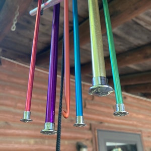 a 20 inch windchime from stringing old knitting needles and crochet hooks through a piece of wood 5 in x 7 in in size.  An additional piece of galvanized metal is used to catch the wind and create the chiming when hook and needles strike each other