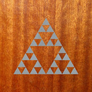 May include: A gray geometric pattern of triangles on a brown wooden surface.