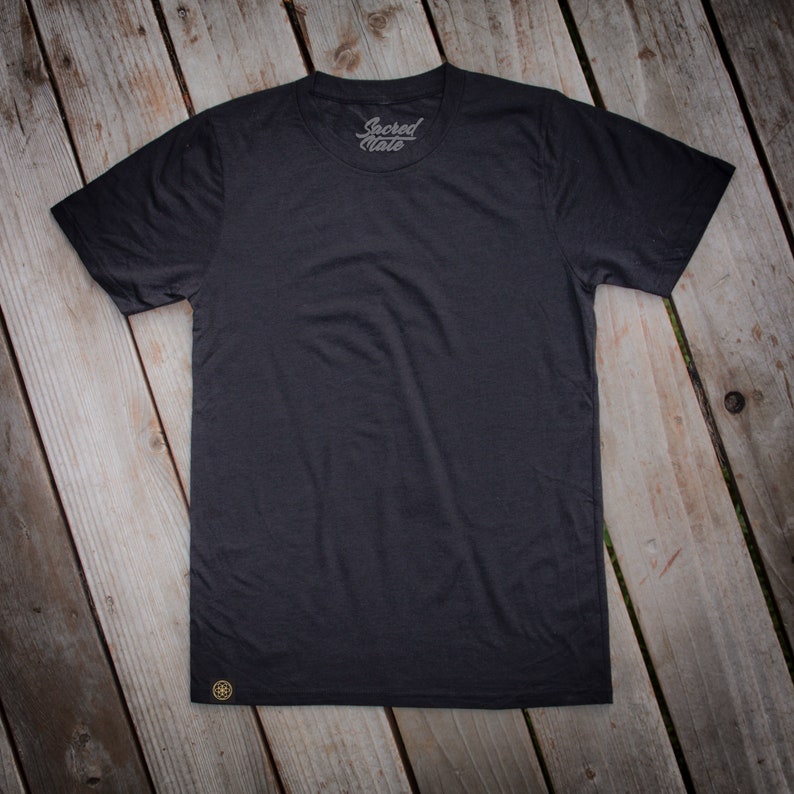 May include: A black t-shirt with a small gold logo that says "Sacred State" on the front.
