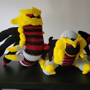 May include: Two crocheted Pokemon plushies, one black, red, and yellow, and the other gray, black, red, and yellow.