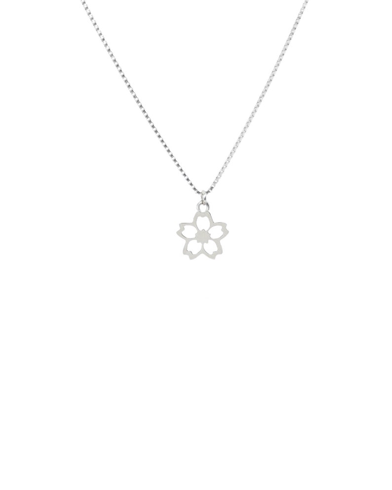 May include: A silver necklace with a floral pendant. The pendant is a five-petal flower design with a small, circular centre. The chain is a fine, box-style chain. The necklace is shown against a white background.