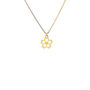 May include: A gold necklace featuring a fine chain and a floral pendant. The pendant is a five-petaled flower design. The necklace is shown against a plain white backdrop.