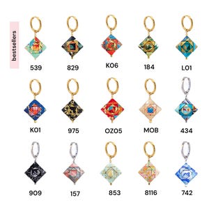 May include: Assortment of 10 gold and silver hoop earrings with colorful patterned charms. The charms are square-shaped and feature a variety of geometric designs and colors.