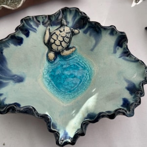 Handmade ceramic pottery blue bowl with turtle in blue glass water