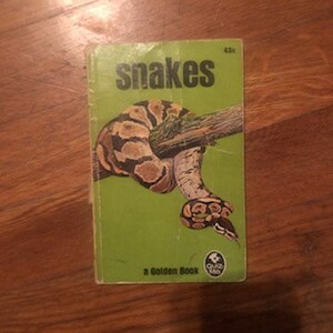 May include: A green and yellow Golden Book titled "Snakes" with a picture of a snake wrapped around a branch.