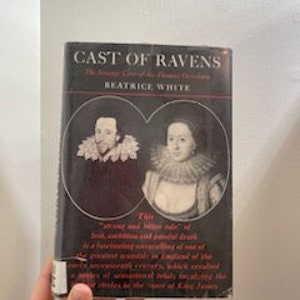 May include: A vintage paperback book titled "Cast of Ravens" by Beatrice White. The cover features a black and white portrait of a man and a woman in period clothing.
