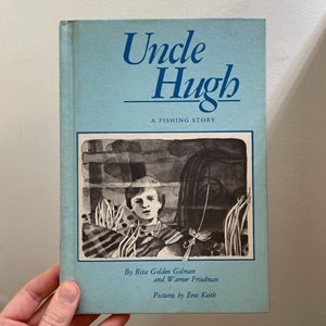 May include: A blue book titled "Uncle Hugh: A Fishing Story" with a black and white illustration of a boy looking out from behind a cage. The book is by Rita Golden Gelman and Warner Friedman, with pictures by Eros Keith.