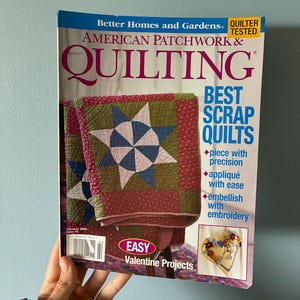 May include: A February 2005 issue of American Patchwork & Quilting magazine. The cover features a green, red, and blue star-patterned quilt, the text Best Scrap Quilts, and a small heart-shaped embroidered project with the text Easy Valentine Projects.