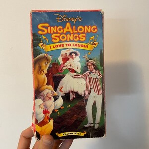 May include: A VHS tape case for Disney's Sing Along Songs, Volume Nine, featuring a colorful illustration of characters from the movie Mary Poppins. The text on the case reads "Disney's Sing Along Songs I Love to Laugh!"