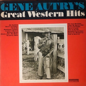 May include: A red and black vinyl record cover featuring a photo of Gene Autry, a country music singer, standing in front of a wooden fence. The cover title is "Gene Autry's Great Western Hits" and lists the songs included on the record.