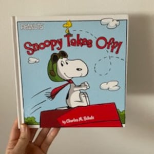Hardcover Peanuts Snoopy Takes off by Charles M. Schulz, Snoopy