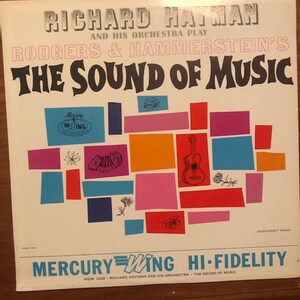 K&ouml;nnte beinhalten: Ein Vintage-Vinyl-Schallplattencover mit einem farbenfrohen abstrakten Design mit einer Gitarre und Blumen. Das Album tr&auml;gt den Titel "The Sound of Music" von Richard Hayman und seinem Orchester, das Musik von Rodgers & Hammerstein spielt. Das Plattenlabel ist Mercury Wing Hi-Fidelity.