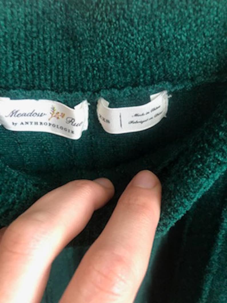 Puede incluir: Un su&eacute;ter verde oscuro, suave y peludo con una etiqueta blanca que dice "Meadow Rue by Anthropologie".
