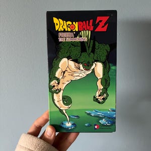 May include: A Dragon Ball Z VHS tape titled Frieza The Summoning. The cover features a green, muscular, horned creature with red eyes hovering over a landscape. The Funimation logo is printed in the bottom right corner of the black and green box.