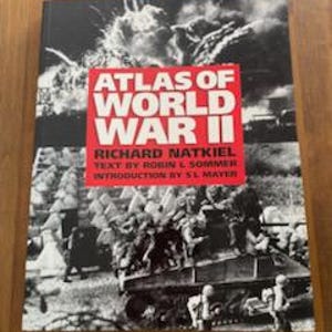 May include: A hardcover book titled "Atlas of World War II" with a black and white photograph of military vehicles and soldiers. The title is in white letters on a red background. The author's name is Richard Natkiel.