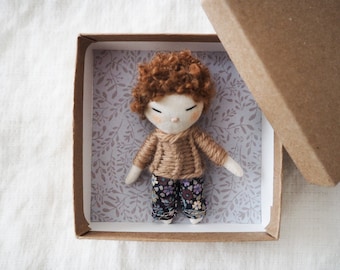 Micro miniature pocket boy doll in a kraft and floral box