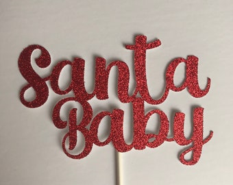 May include: Red glitter cake topper with the words "Santa Baby" in a cursive font.