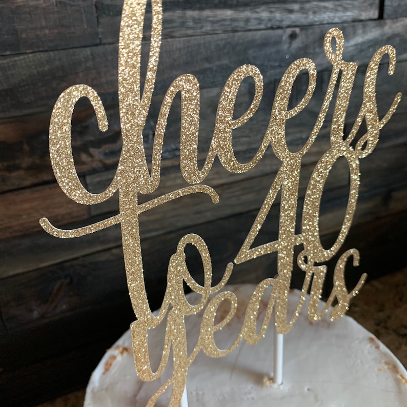 May include: Gold glitter cake topper with the text "Cheers to 40 years".