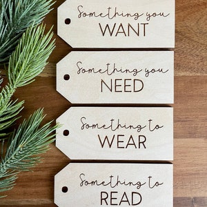 May include: Four wooden gift tags with the text "Something you WANT", "Something you NEED", "Something to WEAR", and "Something to READ" on them.