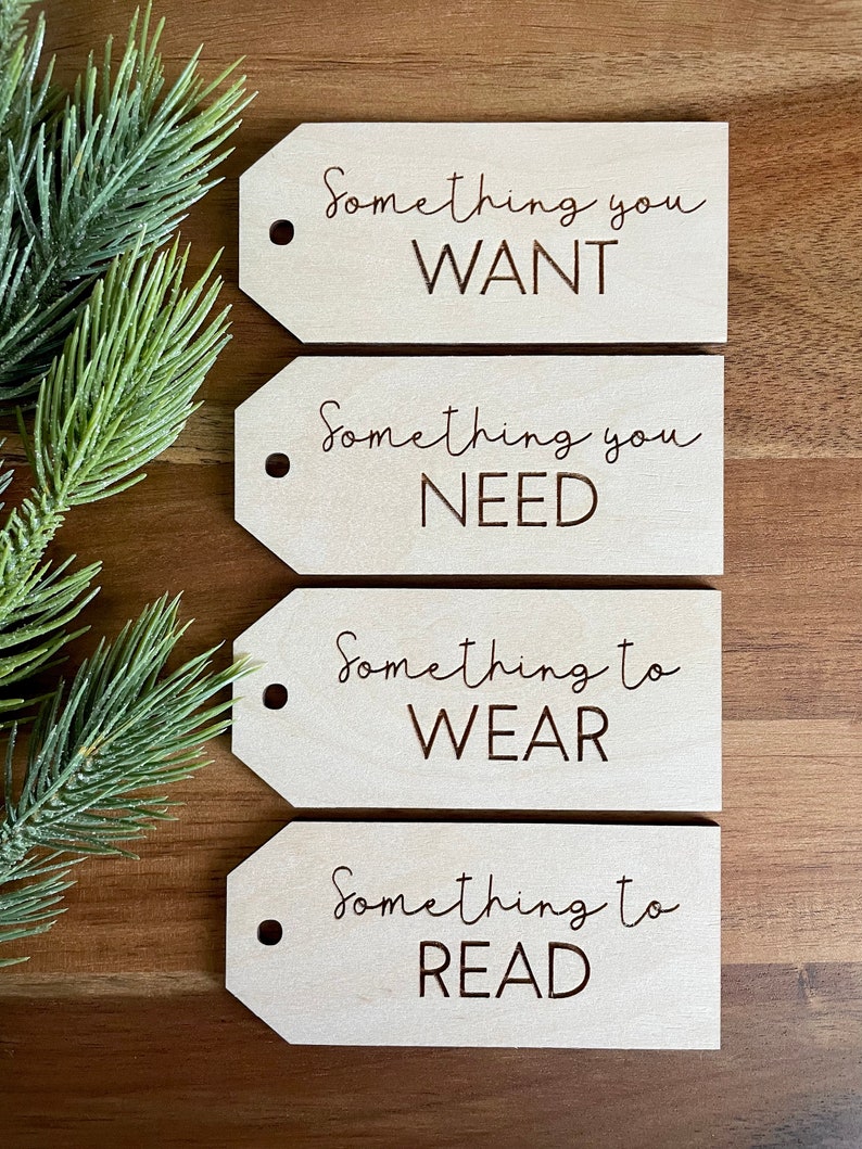 May include: Four wooden gift tags with the text "Something you WANT", "Something you NEED", "Something to WEAR", and "Something to READ" on them.