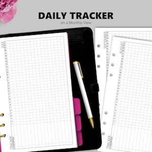 May include: A white daily tracker with a grid pattern, designed for monthly use. The tracker includes the months of July, August, and September. The tracker is shown in a binder with a pink cover.
