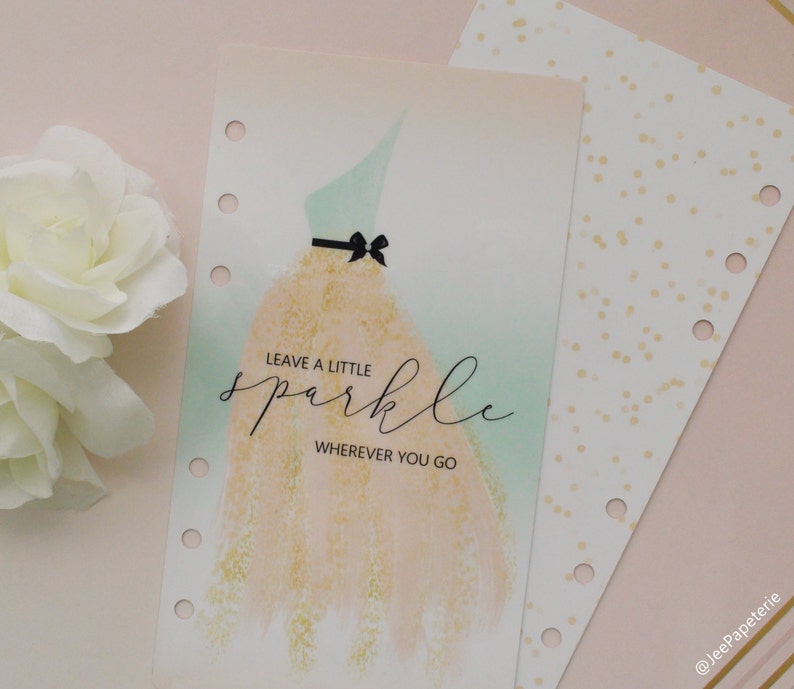Pode incluir: Uma inser&ccedil;&atilde;o de planejador com uma ilustra&ccedil;&atilde;o em aquarela de um vestido, com um corpete verde-menta e uma saia dourada. O texto "LEAVE A LITTLE sparkle WHEREVER YOU GO" est&aacute; escrito em it&aacute;lico. Uma segunda inser&ccedil;&atilde;o com pontos dourados &eacute; vis&iacute;vel.