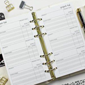 May include: A white planner with a gold binder and black text that reads "project list". The planner has columns for project, steps/tasks, project due, done, due, and done.
