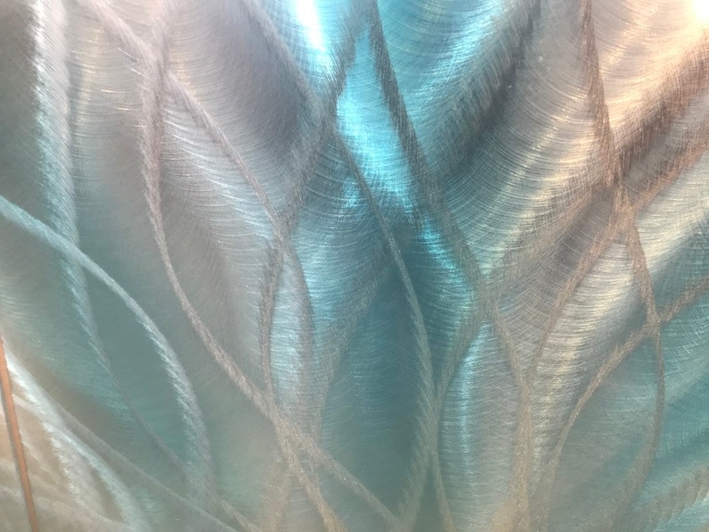 May include: Abstract metallic background with a brushed silver and blue finish. The surface has a swirling pattern of lines and curves.